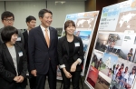 신한은행 이신기 부행장(앞줄 왼쪽에서 두 번째)이 ‘S20 글로벌 청춘 여행기’공모전 수상자들과 함께 서울 중구 태평로 소재 신한은행 본점 로비에 전시된 여행기 사진들을 바라보는 