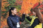 참가자가 단풍잎을 만지며 봉사자에게 단풍잎 색깔을 물어보고 있다
