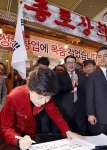 4060 인생설계박람회 종로상회 부스에서 방명록을 적고 있는 박근혜 대통령 당선인.