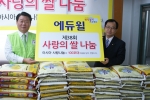 아시아사랑나눔 김종구 총재(왼쪽)와 에듀윌 윤병현 이사(오른쪽)가 ‘사랑의 쌀’ 기증식을 하고 있다.