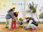 29일 서울시와 이브자리가 주최한 탄소 상쇄 숲 조성 행사에서 참가자 가족들이 나무를 심고 있다