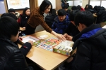 천안북중학교 학생을 대상으로 금융 기초상식 교육과 보드 게임을 통한 용돈관리 체험을 하고 있다.