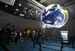 情 나눔 우주과학 캠프에 참가한 아동복지시설 청소년이 SOS에 투사된 지구를 유심히 바라보고 있다(장소: 국립고흥청소년우주체험센터 SOS실)