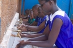 우간다의 한 학교에서 어린이들이 수업 시작에 앞서 손을 씻고 있다.
