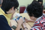 도봉노인종합복지관 어르신이 효문중학교 청소년에게 스마트폰을 배우고 있다