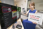 KT 홍보 모델이 올레 tv에서 비스트 홍콩 콘서트를 예약 구매할 수 있는 화면을 소개하고 있다