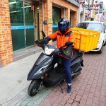 오토바이를 타고 있는 무료급식소 봉사자