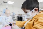 소아암 치료 중인 어린이가 병원에서 선물받은 장난감을 구경하고 있다