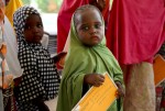 나이지리아 난민들을 위해 백신 캠페인을 실시하고 있다. 어린 소녀가 백신 카드를 손에 쥔 채 차례를 기다리고 있다