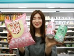 GS리테일 직원이 GS25에서 벚꽃팝콘과 벚꽃딸기에이드, 벚꽃청포도에이드를 들고 포즈를 취하고 있다