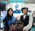 GS25 직원과 부릉 배달원이 요기요앱으로 주문된 배달 상품을 들고 포즈를 취하고 있다