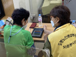 생애전환기 경험 프로그램 참여자가 어르신에게 스마트폰 사용법을 교육하고 있다