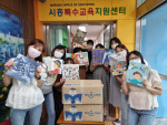 예스24가 시흥특수교육지원센터에 어린이 도서 100권을 기증하고 기념 촬영을 하고 있다