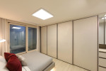 LX하우시스 리사이클 가구용 필름이 붙박이장 표면 마감재로 적용된 두산위브더제니스 오션시티 모델하우스의 침실 공간