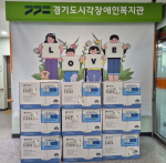 경기도시각장애인복지관 포스터 앞에 후원받은 선풍기가 놓여 있다