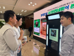 현대건설 본사 로비에 설치된 스위트앤데이터 ‘AI 포토부스’에서 임직원들이 테마를 선택해 촬영을 체험하고 있다