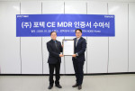 포텍 본사에서 열린 EU MDR 인증서 수여식에서 포텍 고안수 대표(왼쪽)와 TÜV NORD Korea 김광태 대표이사가 기념촬영을 하고 있다