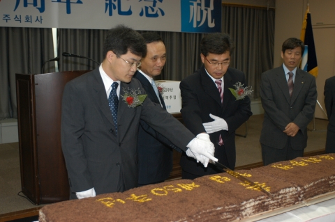 우리증권 이팔성 사장(가운데)이 김성호 신임 노조위원장(우측)과 홍성표 전임 노조위원장(좌측)과 축하 떡을 자르고 있다.