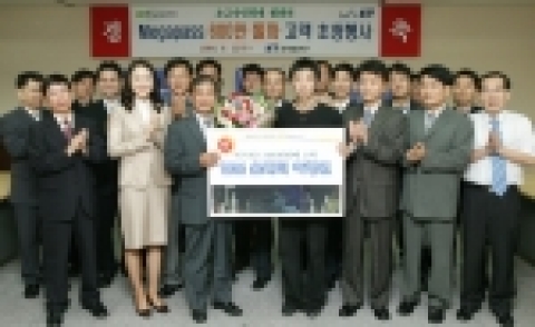 KT 메가패스 600만번째 고객인 김명희씨(46세, 주부)의 아들 양승환씨(우측)가 최문기 마케팅기획본부장(좌측)으로 부터 선물을 증정받은 후 기념촬영을 하고 있다.