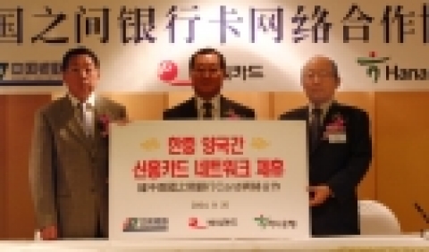윤교중 하나은행 수석부행장(오른쪽), 이호군 BC카드사 사장(가운데), 류영춘 은련 부총재(왼쪽)가 현금인출 등 신용카드 업무제휴를 체결한 뒤 손을 맞잡고 있는 모습