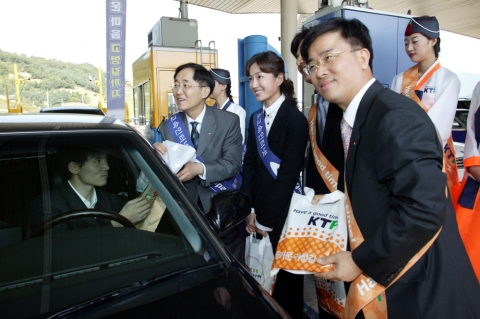 이용경 KT사장.탤런트 손지창 오연수 부부.표현명 KTF전무(왼쪽부터) 와 임직원 등이 하남 동서울톨게이트에서 귀성차량에게 선물을 나누주고 있다.