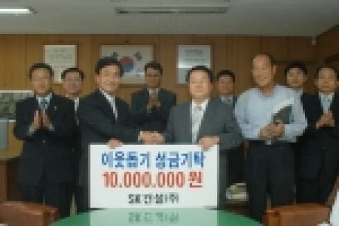 SK건설 건축부문장 진영헌 전무(왼쪽)가 광주광역시 김종식 서구청장(오른쪽)에게 이웃돕기성금 1천만원을 전달하고 있다.
