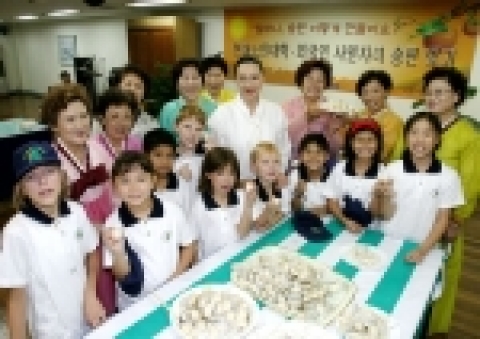 노인대학 할머니들이 외국인 어린이들과 송편을 빚고 있는 장면 