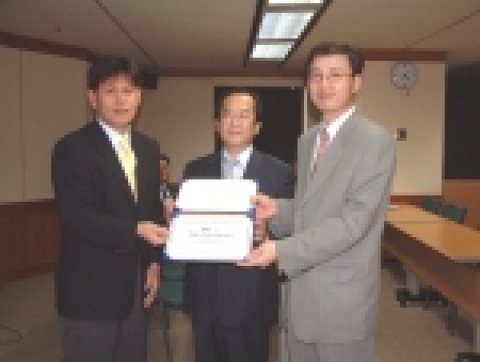 SK C&C R&D센터장 이윤성 상무(오른쪽)가 CMM 선임심사원인 장택상(TQMS)으로 부터 CMM 레벨 4 인증서를 받고 있다.