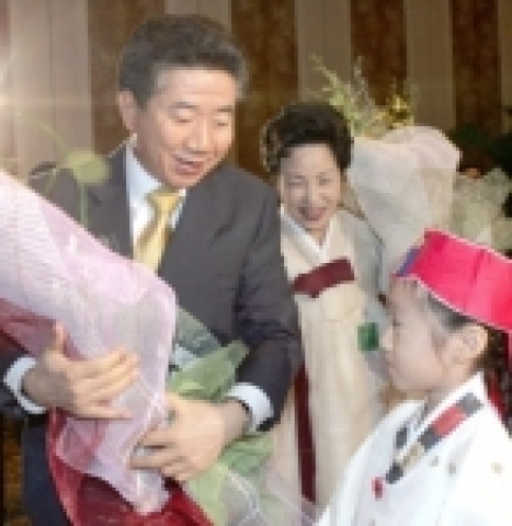노무현 대통령 내외가 동포간담회서 화동으로부터 꽃다발을 받고 있다. 