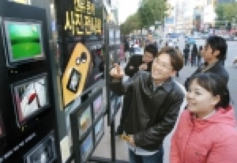 고객이 캔유폰카 사진전시회에서 캔유로 찍은 사진을 감상하는 모습.
