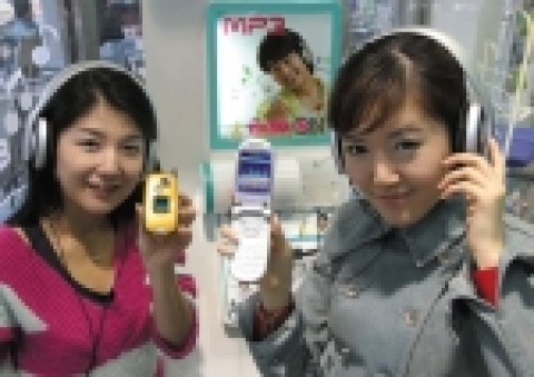 LG텔레콤 MP3폰 이용자가 유무선 통합 음악서비스인 뮤직온 사이트에서 음원을 다운로드 받아 MP3폰으로 듣는 모습.