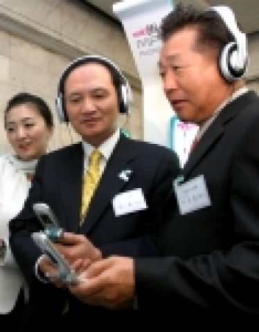 LG텔레콤 남용 사장과 한국음악산업협회 박경춘 회장이 뮤직온을 통해 MP3를 다운로드 받아 시연해 보이고 있는 모습.