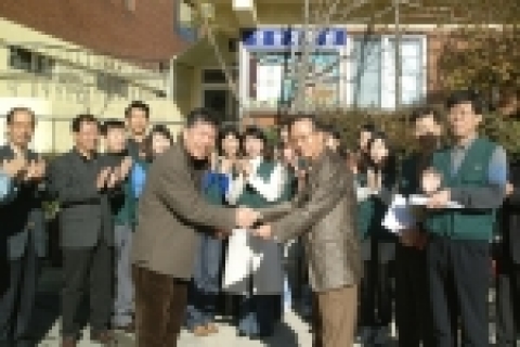 서로 악수라고 있는 부산은행 김창고 상무, 왼쪽은 영광재활원 이창쇠 원장