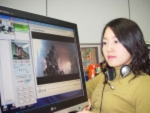 한 고객이 데이콤에서 제공하는 IPV6 기반의 VOD로 영화를 감상하면서 MIM으로 걸려 온 전화를 받고 있다. 
