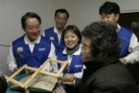 배정충 삼성생명 사장(왼쪽)이 신당2동에 혼자 사시는 李모 할머니(73세)댁을 방문, 쌀을 전달하고 집안에 가구들을 보수해주고 있는 모습