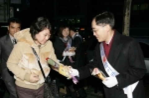 KT 이용경 사장이 3일 아침 선릉역 주변에서 고객들에게 복조리와 장미꽃을 주면서 새해 인사를 하는 모습.