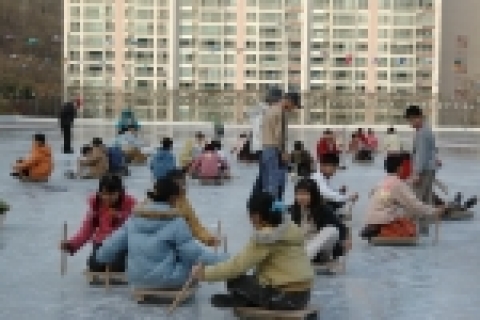 군포시 당동배수지에 마련된 씽씽썰매장을 찾은 청소년들이 썰매를 타며 즐거워하고 있다