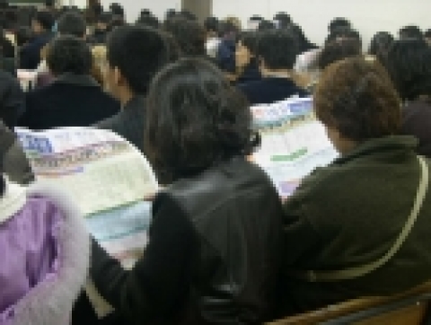 서울 노량진 비타에듀 한샘학원 겨울방학특강 접수를 위해 강의실에서 기다리며 시간표를 보고 있는 수험생 학부모들