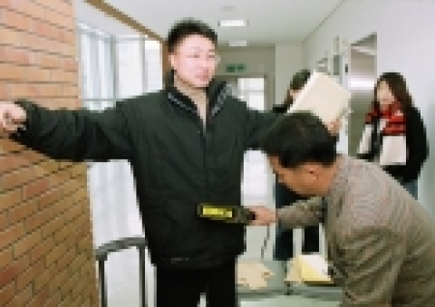 한 수험생이 복도감독에 의해 검색을 받고 있는 모습