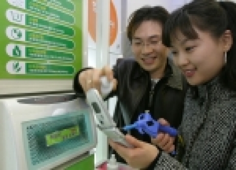한 고객이 LG텔레콤 직영점에서 휴대폰 클리닝 서비스를 제공받고 있는 모습.