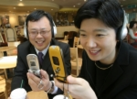 30대 중반 회사원이 뮤직온에서 다운로드 받은 디지털음악을 MP3폰으로 듣고있다.