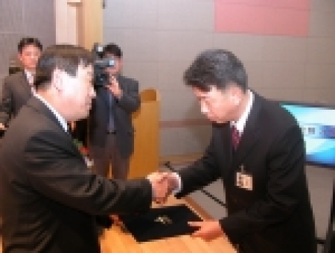 이희범 산업자원부 장관은 특허넷II 시스템 개통 유공자 표창에서 최종인 과장에게 장관상을 수여하고 있다.