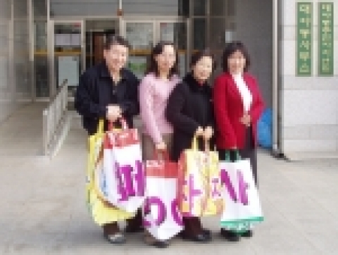폐현수막으로 리폼한 장바구니를 들고 환하게 웃고 있다