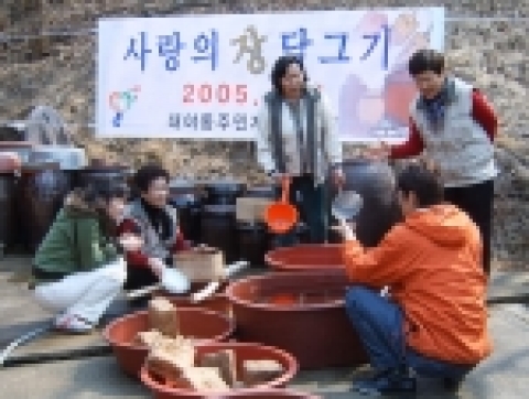 장 담그기 행사에 앞서 메주를 들고 환히 웃고 있는 농민