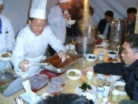 삼성전기 기판사업부장 송광욱전무가 신화창조 포장마차에 방문한 직원에게 자신이 만든 음식을 제공하고 있다