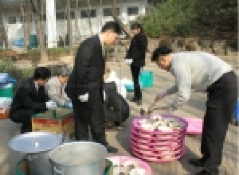 아이마켓코리아 직원들이 남산공원에서 성수교회 부설 성수복지회와 함께 무의탁노인과 노숙자를 대상으로 무료 급식을 하고 있다. 