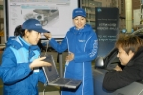 경기도 현대오일뱅크 한 주유소에서 주유 고객이 스마트카드 결재후, 전문 홍보 도우미가 안내하는 자신의 차량 정보를 대형 디스플레이에서 검색하고 있는 모습