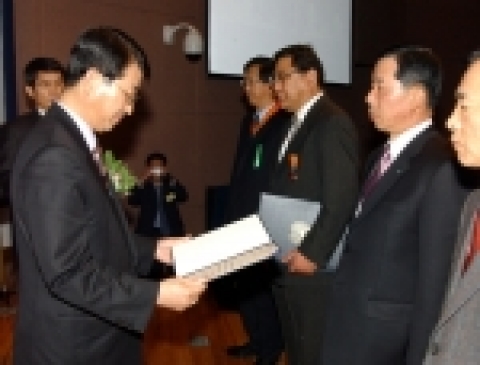 한진해운 해사본부장 한충전 전무가 과학기술부 최석식 차관으로부터 대통령 표창(흉장)을 받고 있다.