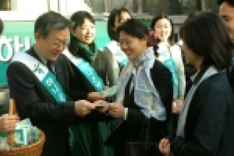 김종열은행장과 직원들이 을지로입구 전철역에서 꽃바구니에 가득담긴 꽃씨를 나눠주고 있는 모습임