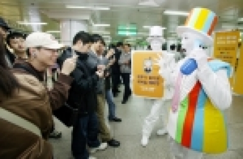 지하철 사당역 역사에서 지나가는 승객들이 KTF 모티켓 판토마임 공연을 관람하고 있다.